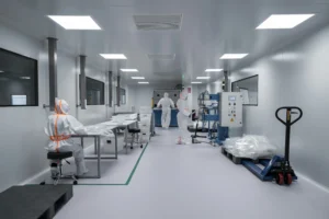 Medewerkers in beschermende pakken die werken in een cleanroom met een verhoogde vloer